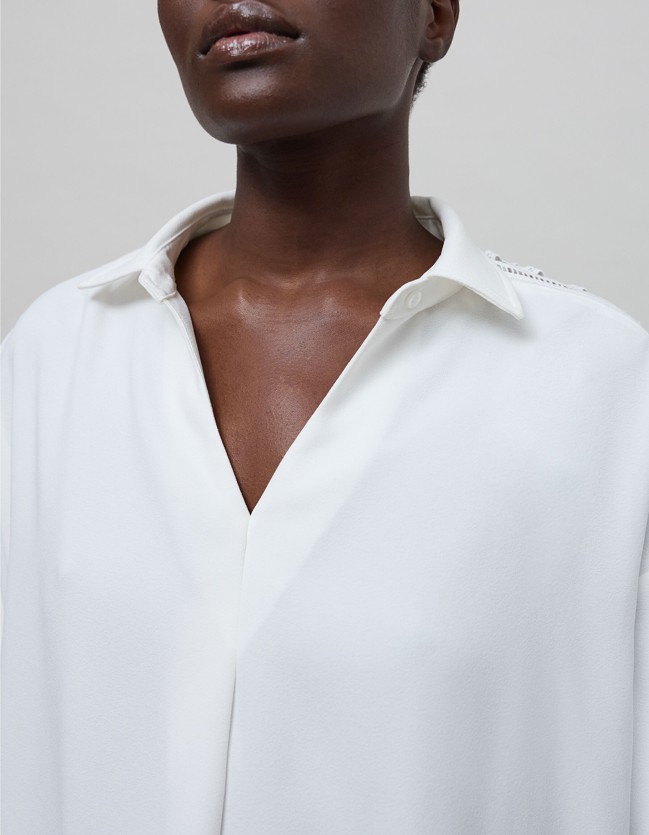 Women's white blouse with graphic lace sleeves